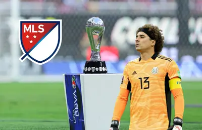 Guillermo Ochoa junto al trofeo de la Liga Mx y el logo de la MLS/ Foto TUDN.