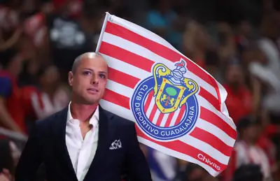 Javier Chicharito Hernández de traje y bandera del Guadalajara/Foto Chivas.