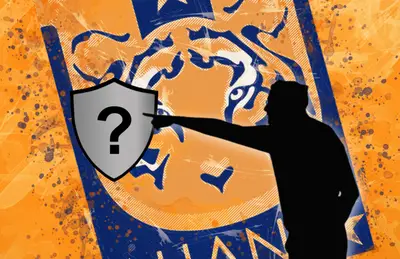 Thomas Tuchel en sombra señalando escudo sin equipo/Foto Besthqwallpapers.com