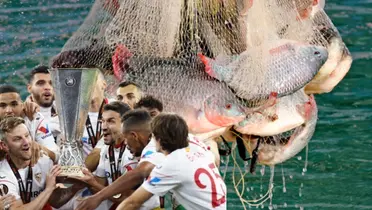 Jugadores del Sevilla levantando la Europa League junto a pescados / FOTO X