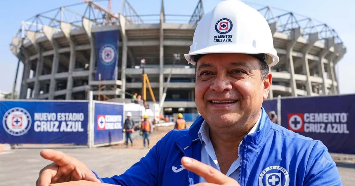 Víctor Velázquez con un casco de construcción y atrás el estadio de Cruz Azul en construcción